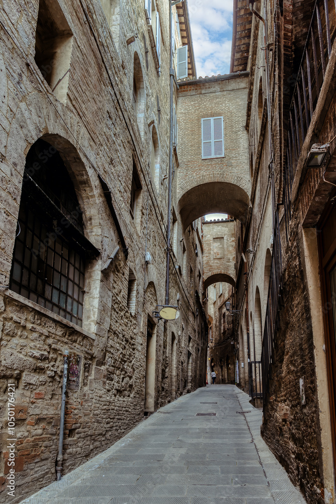 The narrow, cobblestone streets of Perugia, where ancient stone buildings and arches create a captivating atmosphere steeped in history. Perugia, Umbria, Italy.