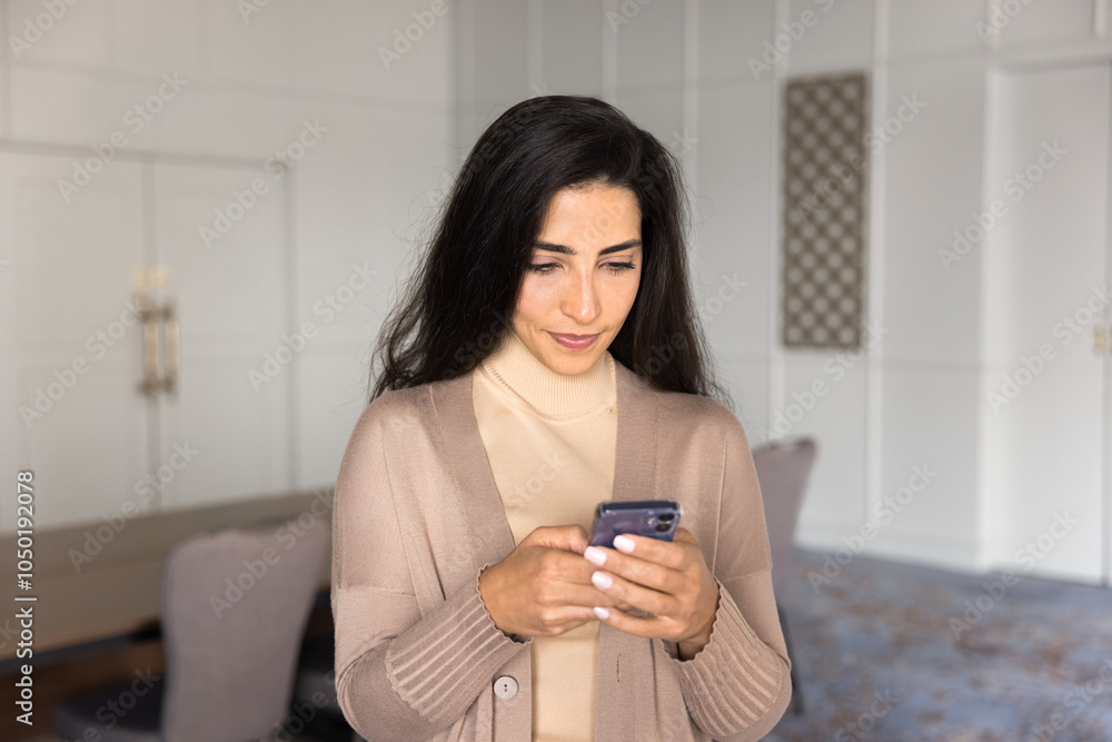 Focused Hispanic business leader woman typing on smartphone in office meeting room space alone. Young female company worker browsing website, using online bank application on mobile phone Focused Hispanic business leader woman typing on smartphone in office meeting room space alone. Young female company worker browsing website, using online bank application on mobile phone