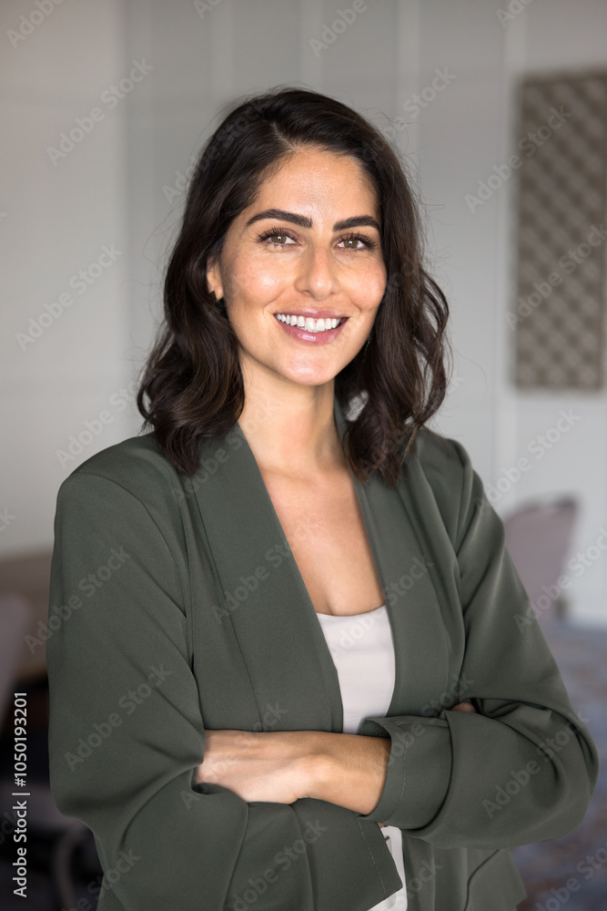 Happy confident Hispanic businesswoman looking at camera with toothy smile, posing with arms crossed. Beautiful young female business leader, executive, professional woman vertical portrait Happy confident Hispanic businesswoman looking at camera with toothy smile, posing with arms crossed. Beautiful young female business leader, executive, professional woman vertical portrait