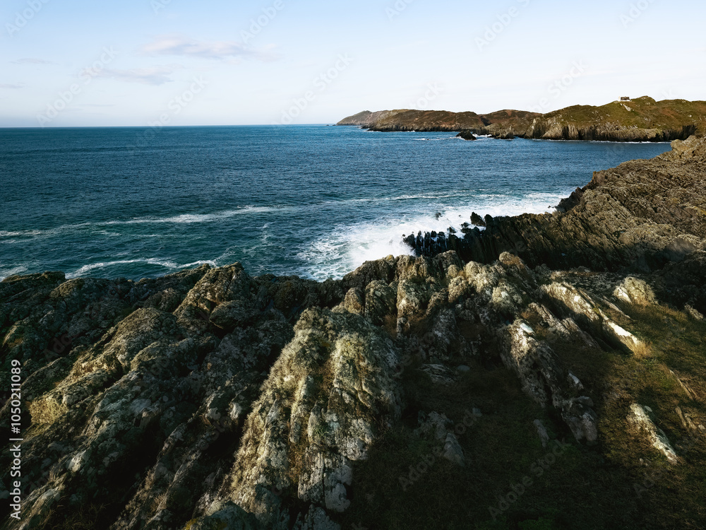 The stunning coastal view features rugged rock formations meeting the tranquil ocean waves, creating a picturesque landscape under a clear sky. The stunning coastal view features rugged rock formations meeting the tranquil ocean waves, creating a picturesque landscape under a clear sky.