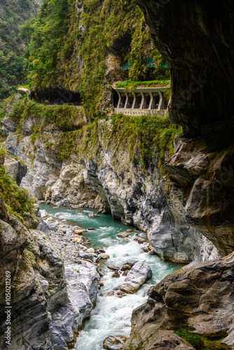 Breathtaking view of a lush green gorge, showcasing a river flowing between dramatic rocky cliffs at the Tunnel of Nine Turns in Taroko National Park in Xiulin, Hualien, Taiwan photo