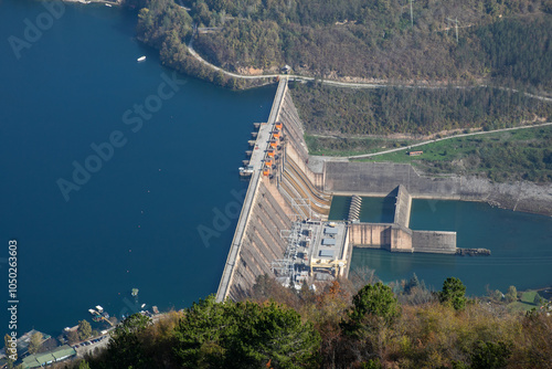 Aerial view of a hydroelectric dam in a lush landscape, illustrating renewable energy solutions and environmental sustainability challenges photo