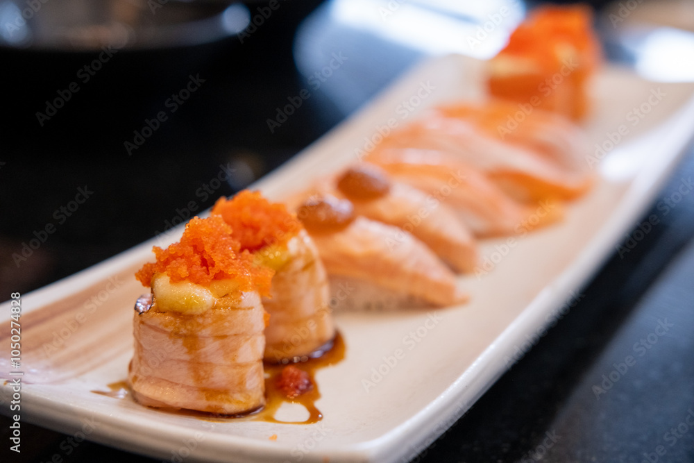 Salmon roll and salmon sushi served on plate Salmon roll and salmon sushi served on plate