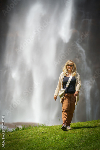 A cool looking female woman walks away form the waterfall of Acquafraggia in Borgonuovo, Lombardy, Italy. photo