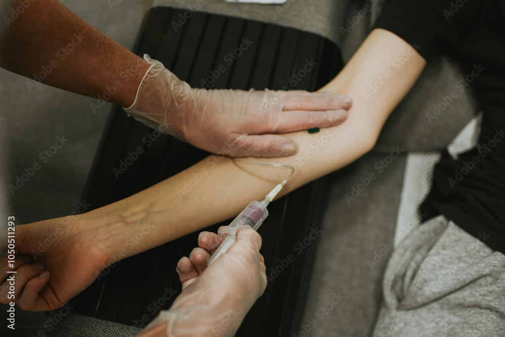 Fototapeta premium a nurse in gloves takes blood from a vein for analysis using a needle and a vacutainer