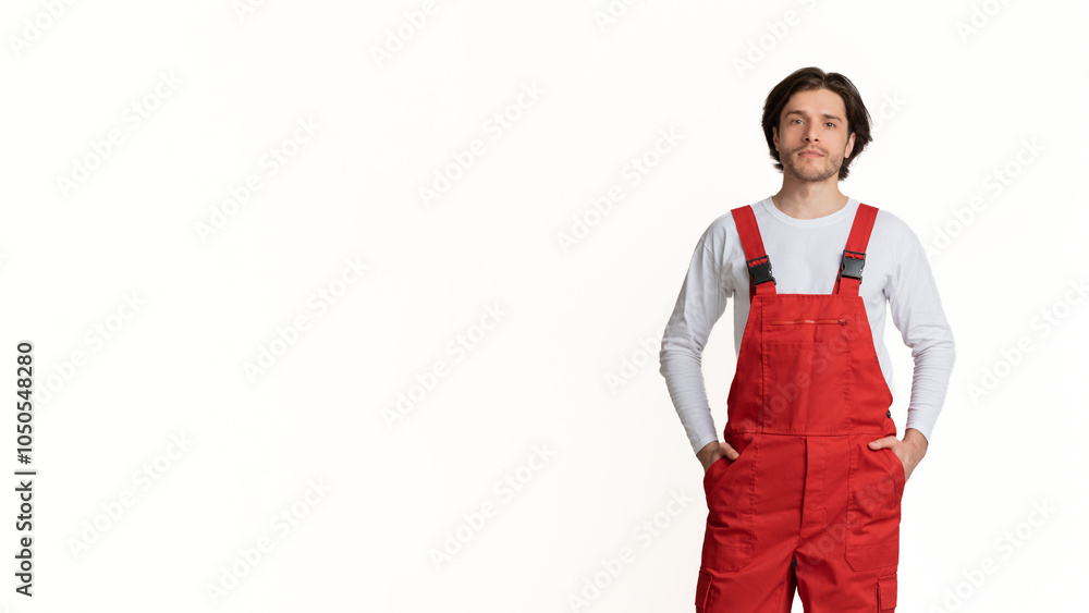 Portrait of young handyman wearing work clothes posing over light studio background, full-length shot Portrait of young handyman wearing work clothes posing over light studio background, full-length shot