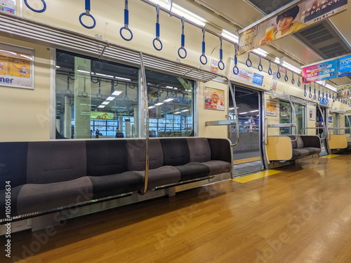 Osaka, Japan - 01.01.2024: Interior of a women-only carriage of Nankai Railway train with empty seats, hanging handrails, windows, and advertisement when stopped at Namba Station (Nankai) photo