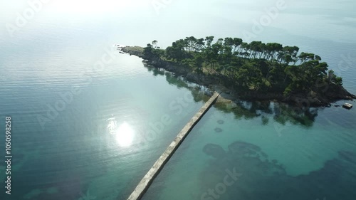 small uninhabited island in the Adriatic Sea, Croatia, shot by a drone, early autumn, late morning, the camera is stationary