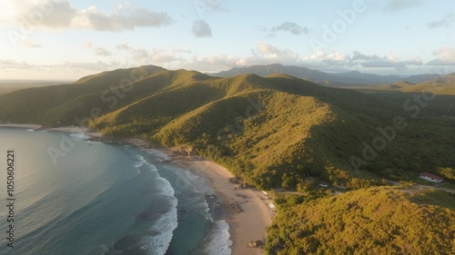 Aerial view of a secluded beach with lush green mountains in the background.