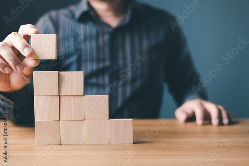 hand of a businessman stacking wood empty ten blocks with copy space for text or symbols, development concept for growth success process. photo