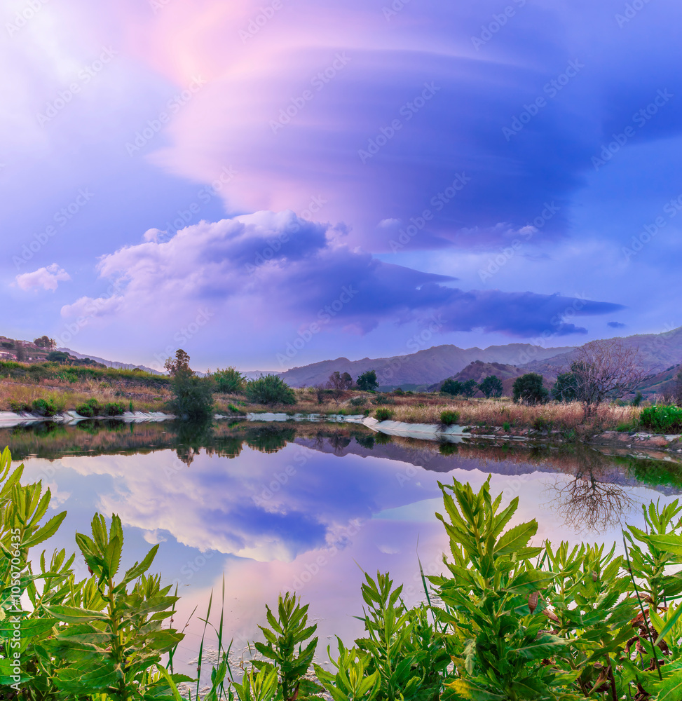 Amazing view at scenic landscape on a beautiful river and colorful sunset with reflection on water surface and glow on a background, spring season landscape Amazing view at scenic landscape on a beautiful river and colorful sunset with reflection on water surface and glow on a background, spring season landscape