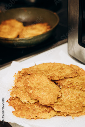 Cooking food on an electric stove. Draniki are fried in a frying pan