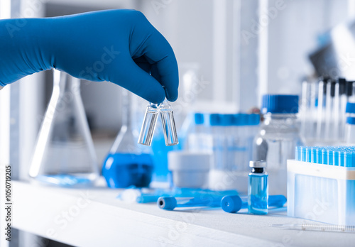 A scientist's hand in a medical glove holds a test tube