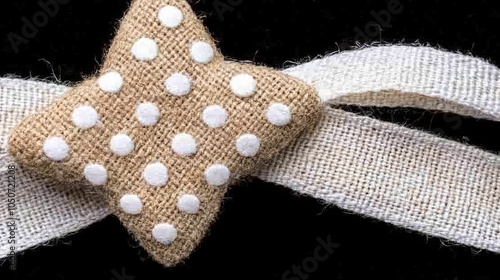 A decorative burlap star with white polka dots, perfect for crafts, home decor, or party decorations. photo