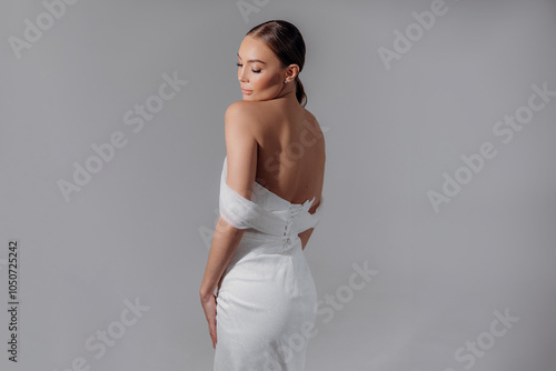 Portrait of a cute girl in a dress with a bare back isolated on a background with light photo