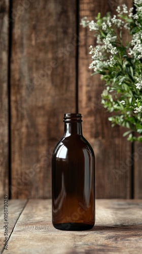 A dark amber glass bottle sits on rustic wood, illuminated by natural light photo