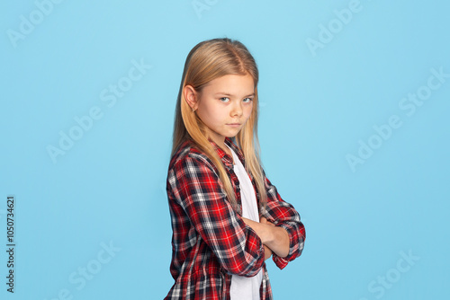 Kids violence. Offended teen boy standing with folded arms, grey panorama background with empty space photo