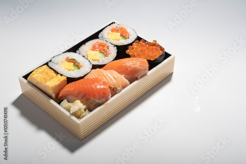 A set of Japanese food, sashimi raw sliced fish, red caviar on white rice in a wooden tray photo