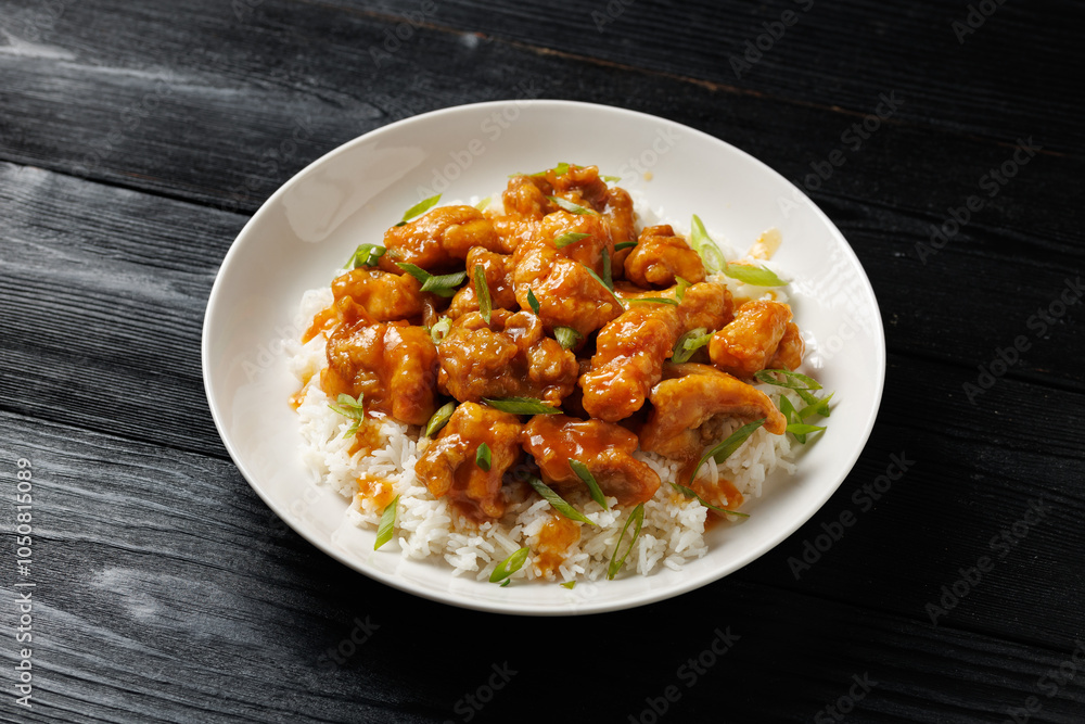 Chinese orange chicken with rice and green onion garnish Chinese orange chicken with rice and green onion garnish
