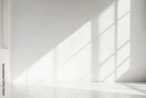 Sunlight streaming through windows creates beautiful patterns on a minimalist white wall in a serene indoor space