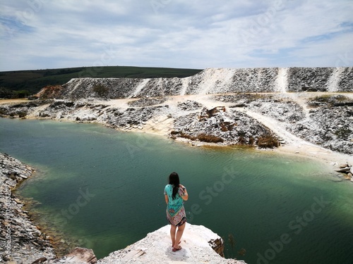 Mulher em pé beira penhasco observando paisagem na Pedreira da Lagoa Azul, Minhas Gerais, Brasil