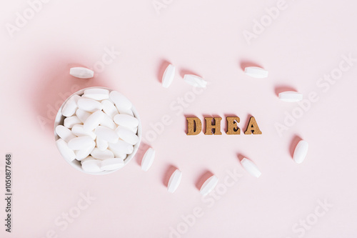 Obraz na płótnie Hormonal supplement DHEA in tablets in a bowl on a pink background w salonie