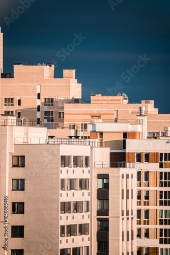 Modern apartment building with multiple balconies located in an urban area reflecting afternoon sunlight and showcasing contemporary architecture
