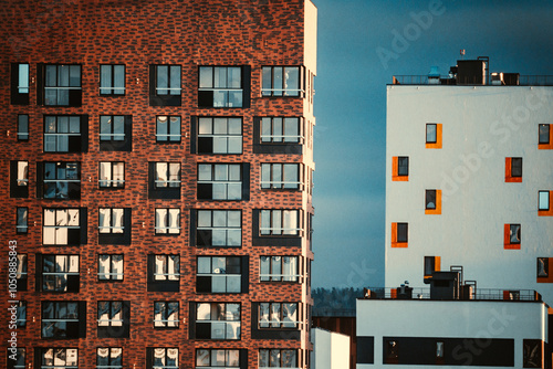 Modern apartment building with multiple balconies located in an urban area reflecting afternoon sunlight and showcasing contemporary architecture