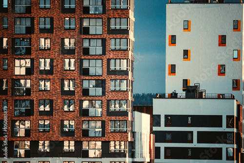 Modern apartment building with multiple balconies located in an urban area reflecting afternoon sunlight and showcasing contemporary architecture