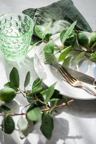 Elegant table setting with feijoas and green glassware photo