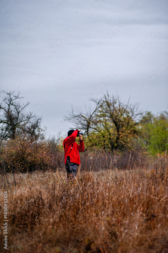 Man in the forest , landscape photographer in work , camera man hiking in the forest , autumn forest ,sunrise . Photographu in forest . Man with hat , brutal boy walking in forest Man in the forest , landscape photographer in work , camera man hiking in the forest , autumn forest ,sunrise . Photographu in forest . Man with hat , brutal boy walking in forest