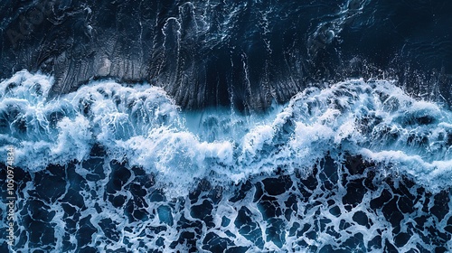 Aerial view of ocean waves breaking and forming white foam.