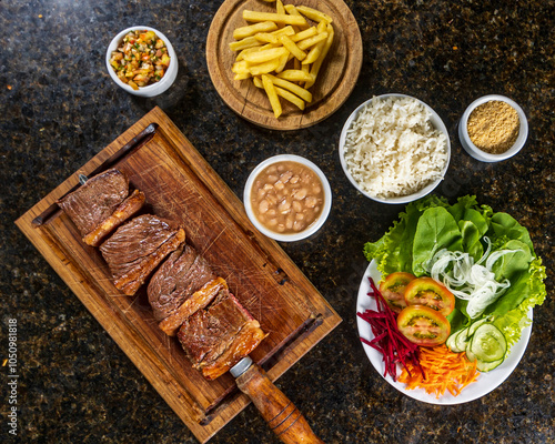 steak with fries, rice, beans and salad photo