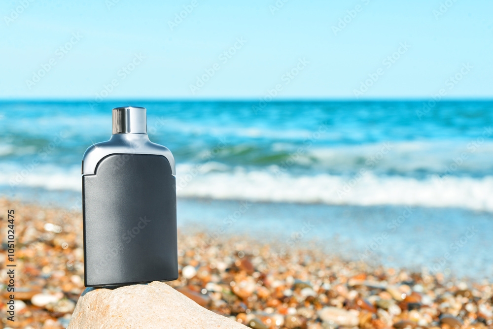 Bottle of elite perfume on stone near ocean, closeup Bottle of elite perfume on stone near ocean, closeup