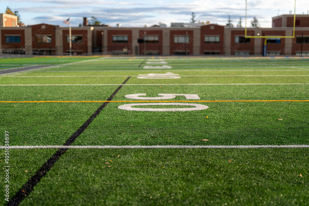 Obraz premium Synthetic turf football 50 yard line, block number, in white along with black lacrosse line and yellow soccer mid field line 