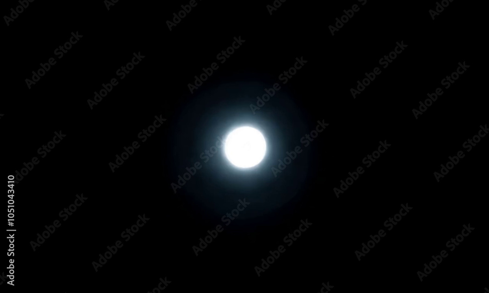 A bright white moon shining in the dark night sky. A bright white moon shining in the dark night sky.