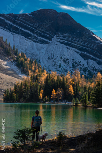 Backpacker girl and her dog, Admiring Autumn Splendor at Chester Lake Alberta Canada Kananaskis Park