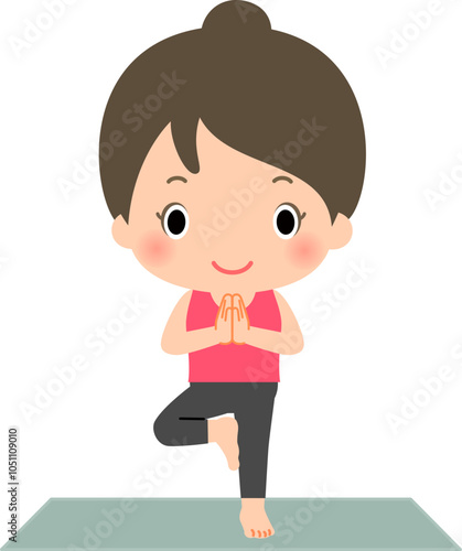 ヨガマットの上で木のポーズをとる女性