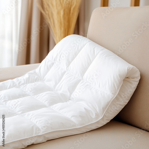 Comfortable White Down Duvet with Quilted Checkered Pattern on Beige Sofa in Modern Boho-Inspired Room photo