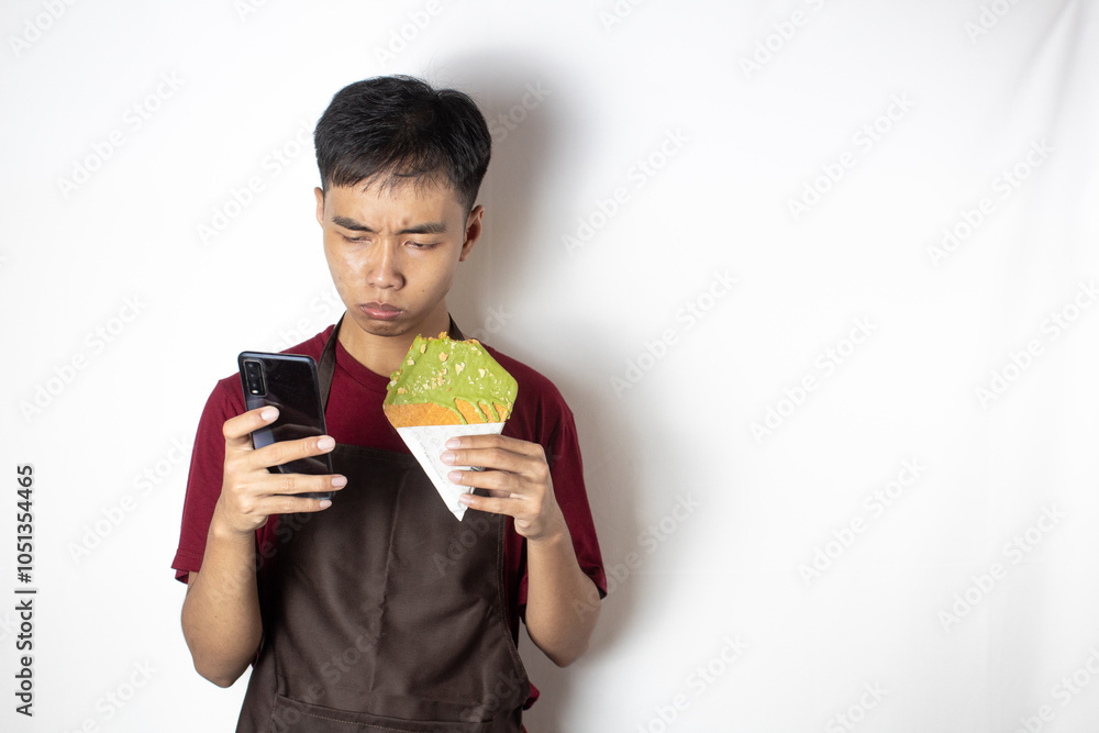 Teen bartender who is surprised with his cellphone also holds snacks Teen bartender who is surprised with his cellphone also holds snacks
