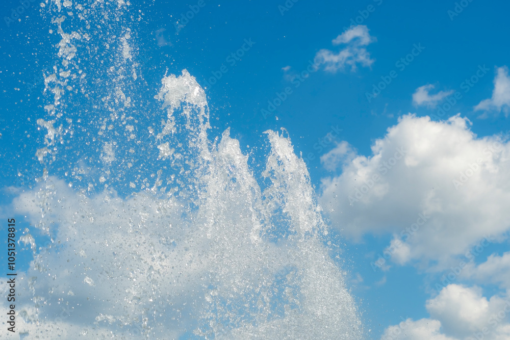 Bright jets of a fountain against a blue sky. Abstract summer, fresh background on the theme of relaxation and happiness. Bright jets of a fountain against a blue sky. Abstract summer, fresh background on the theme of relaxation and happiness.