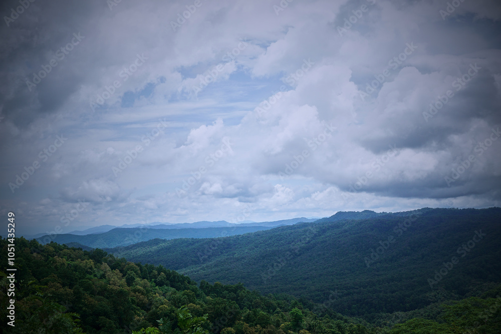 A scenic view of lush green hills under a cloudy sky. A scenic view of lush green hills under a cloudy sky.
