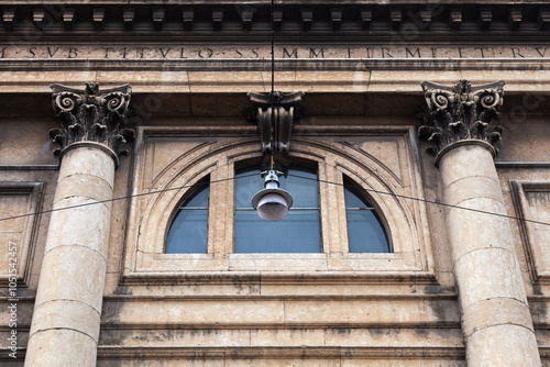 Wallpaper Mural A street lamp hanging on wires against the backdrop of a building facade with columns and a large thermal window. Torontodigital.ca