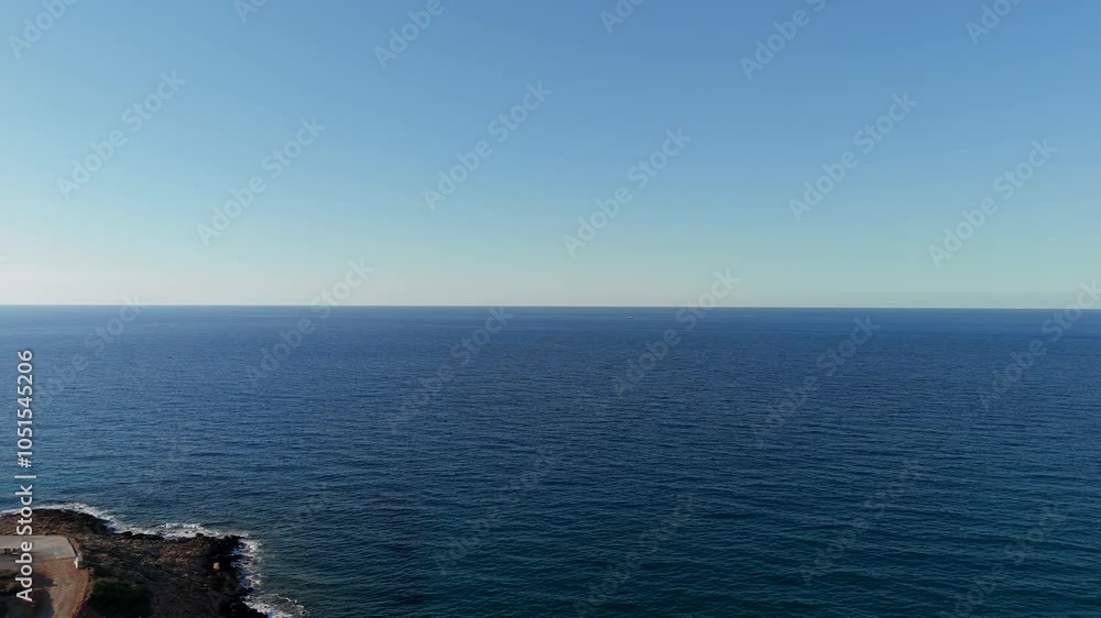 Expansive view of the tranquil blue sea stretching to the horizon under a clear sky in Crete, Greece Expansive view of the tranquil blue sea stretching to the horizon under a clear sky in Crete, Greece