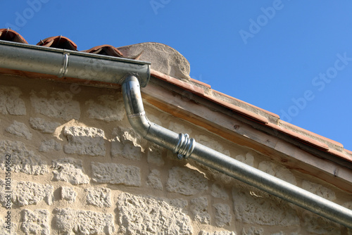 Gouttière en zinc gris sur la façade de la maison en pierre photo