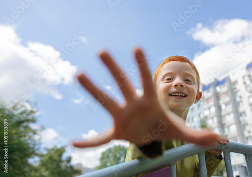 Playful boy showing stop gesture at playground photo