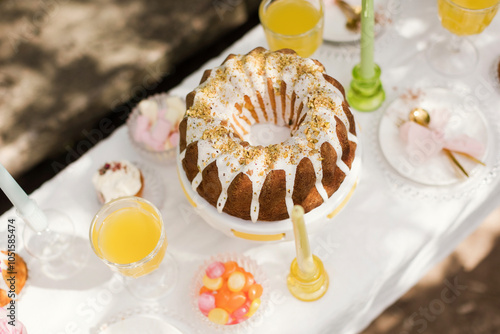 Cake and candies with drinks on table at garden party photo