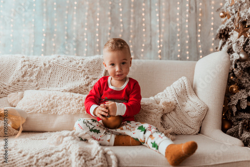 cute little boy at home in christmas decorations holding christmas ball