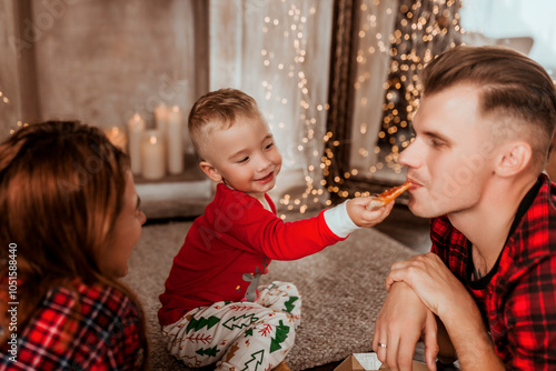 young family at home in Christmas decor eating pizza