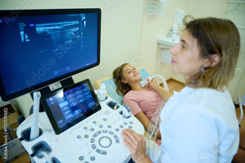 Close up of doctor making thyroid sonogram for kid. Pediatric ultrasound scan. Child ultrasound. Pediatrician scanning neck. Ultrasound examination of lymph nodes. Childhood diseases photo